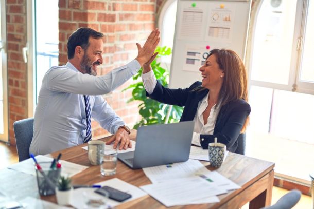 two people high fiving in an indoor office