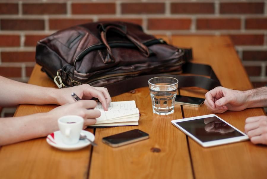 Two People's hands at a table writing notes